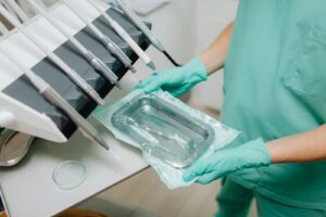 Person in Green Scrub Suit Holding Medical Tools