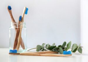 blue and white toothbrush in clear glass jar